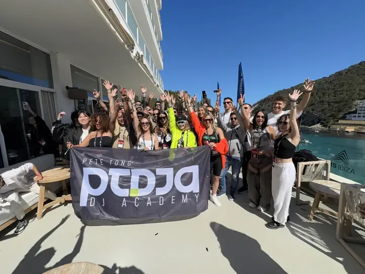 Pete Tong DJ Academy students and mentors together at the Academy meet up in Ibiza, holding the Academy banner
